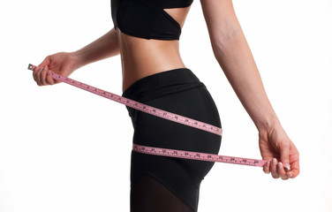 Slim woman measuring her body with a measure tape