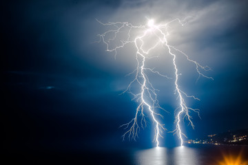 Dual bright lightning that goes into depth of black sea, with branching branches in different...