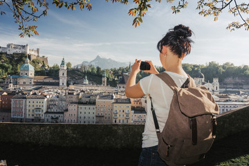 Austria. Salzburg. Young girl tourist taking pictures on mobile phone historic center of Salzburg World Cultural Heritage UNESCO