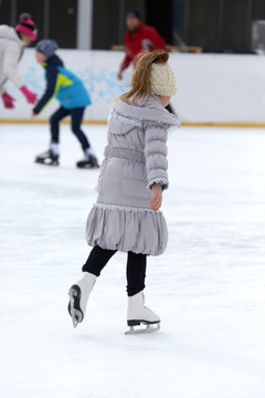 girl skates on ice rink.
