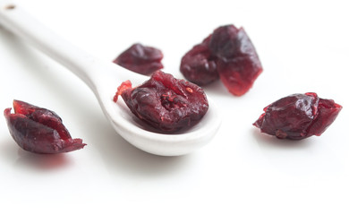 cranberries et petite cuillère sur fond blanc