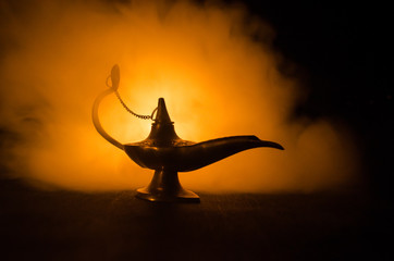 Antique arabian nights style oil lamp with soft light white smoke, Dark background. Lamp of wishes...