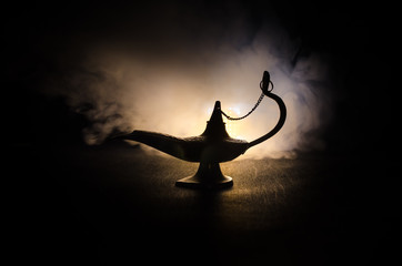 Antique arabian nights style oil lamp with soft light white smoke, Dark background. Lamp of wishes...