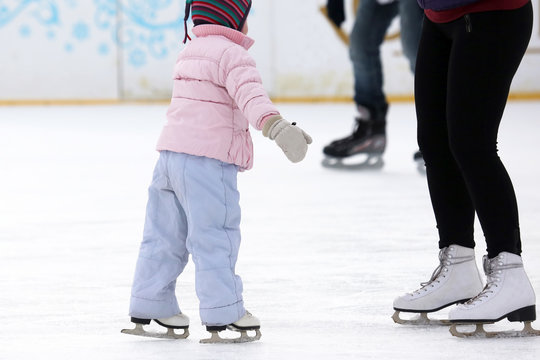 the girl helps the child to skate