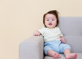 Happy baby boy sitting on a sofa