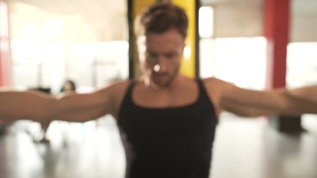 Male with highly developed muscles doing chest fly workout at fast pace in gym