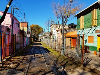 Vías de tren entre casas precarias coloridas