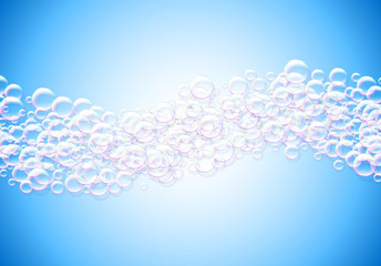 Soap bubbles abstract blue background with rainbow colored airy foam