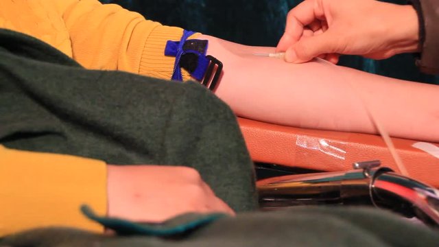 The doctor draws the blood of a voluntary blood donor
