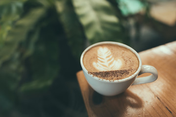 Hot coffee, Capucino coffee on the wooden table in selective focus.