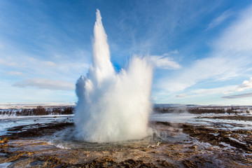 Geyser Erupts with steam in winter - obrazy, fototapety, plakaty
