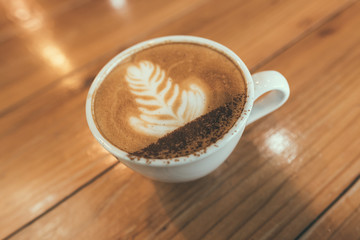 Hot coffee, Capucino coffee on the wooden table in selective focus.