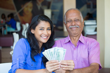 Closeup portrait rich elderly gentleman in pink shirt and lady in blue top holding greenbacks....