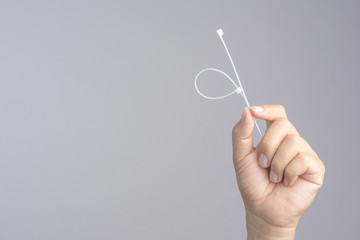 Hand holding self lock plastic cable
