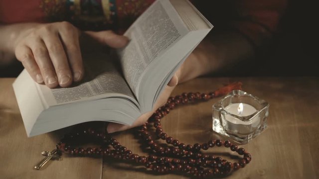 a pair of female hands while reading the bible
