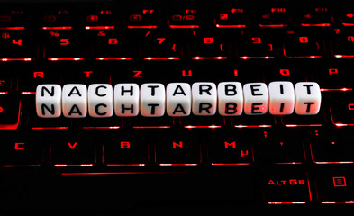 Nachtarbeit Buchstaben auf beleuchteter Tastatur