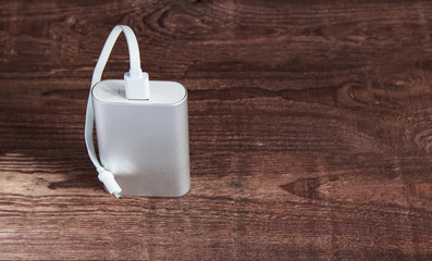 Portable External Battery ( Powerbank ) On A Wooden Desk