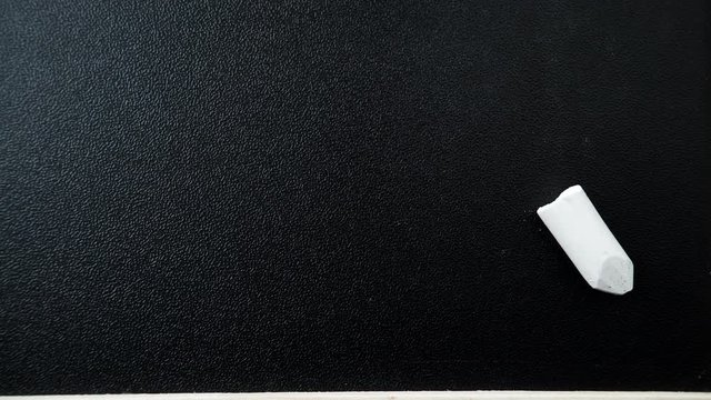 Blackboard with chalk piece as background texture. Empty blank black chalkboard. Dolly sliding shot 4K ProRes HQ codec