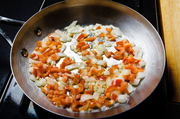 Red peppers and onions sauting in fry pan