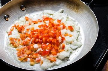 Red peppers and onions sauting in fry pan