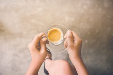 hand holding coffee cup wood desk. vintage effect. top view.