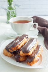 Eclairs with chocolate icing, selective focus