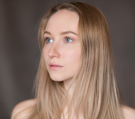 Fototapeta premium Portret pięknej młodej kobiety o niebieskich oczach.