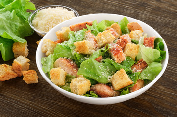 Caesar salad on a wooden background. © vitals