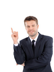 Smiling business man pointing on product or text.