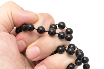 Black beads in hand on a white background