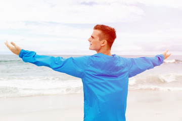 Young man in sport wear with outstretched arms