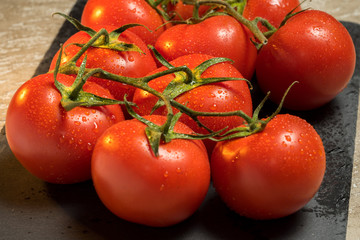 cluster of red ripe wet tomatoes on the table