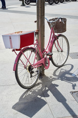 Fototapeta na wymiar Pink retro bicycle parked on street