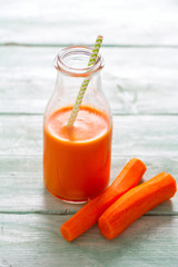 carrot juice on turquoise wooden background