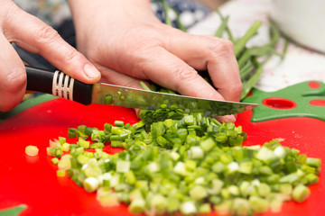 Cook cuts green onions with a knife