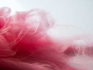 Abstract colored background. Pink smoke, ink in water, the patterns of the universe. Abstract movement, frozen multicolor flow of paint. Horizontal photo with soft focus, blurred backdrop.