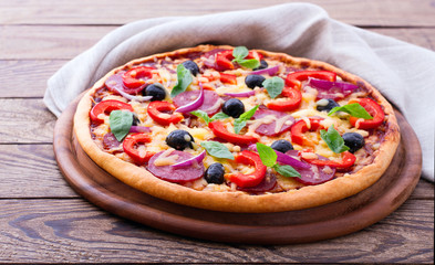Delicious pizza served on wooden table. Italian pizza close up, top view, horizontal