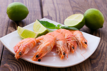 Delicious fresh seafood shrimp with lime on wooden table