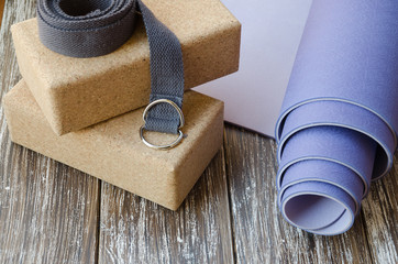 Close up of Accessories or props for yoga, pilates or fitness. Exercise lilac mat, two cork blocks...