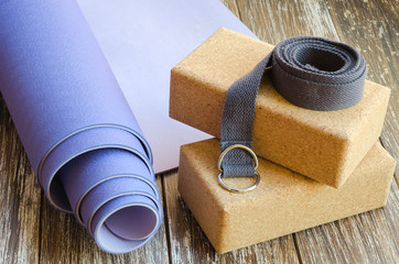 Accessories or props for yoga, pilates or fitness. Exercise lilac mat, two cork blocks and grey...