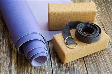 Accessories or props for yoga, pilates or fitness. Exercise lilac mat, two cork blocks and grey...