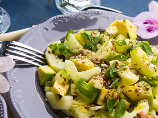 Green Avocado cucumber salad with lettuce, apple and pumpkin flex sunflower seeds. Diet detox food lunch