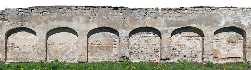 Long fragment of the destroyed ruined arch wall fence from clay bricks and plaster.
