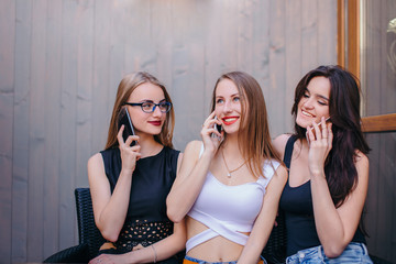 Three woman talk at phone at cafe background
