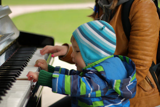 Boy of 2 years old playing piano, selective focus