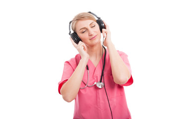 Female nurse listening to headset with eyes closed