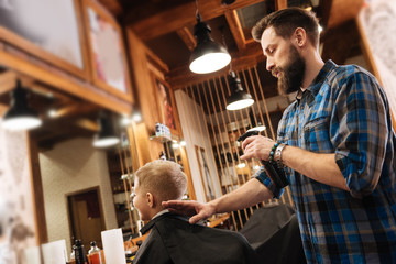 Good looking bearded barber holding a spray