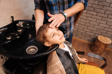 Nice pleasant boy having his hair washed