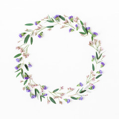 Flowers composition. Wreath made of eucalyptus leaves, purple and pink flowers on white background. Flat lay, top view