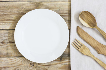 Wooden cutlery on the Table./Wooden cutlery and empty plate on the Table 